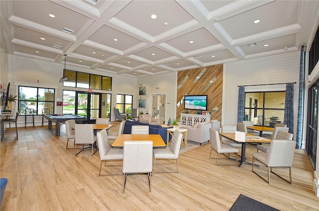 dining space featuring light hardwood / wood-style floors, beamed ceiling, a towering ceiling, and billiards