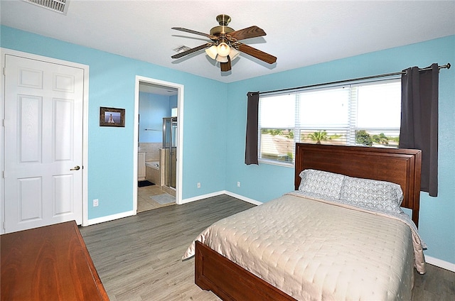 bedroom with hardwood / wood-style flooring, ceiling fan, and connected bathroom