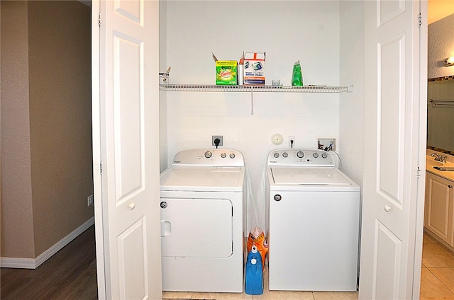 clothes washing area featuring washer and clothes dryer and tile patterned floors