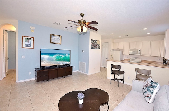 tiled living room with ceiling fan