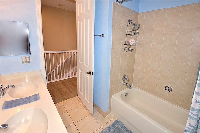 bathroom featuring tile patterned flooring, vanity, and shower / tub combo