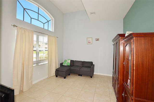 living area featuring light tile patterned floors and a towering ceiling