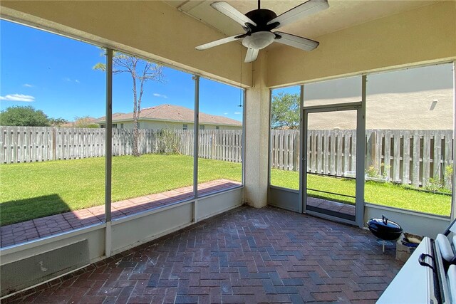 unfurnished sunroom with a healthy amount of sunlight and ceiling fan