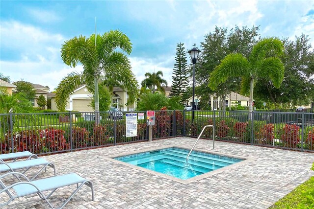 view of swimming pool featuring a hot tub and a patio area