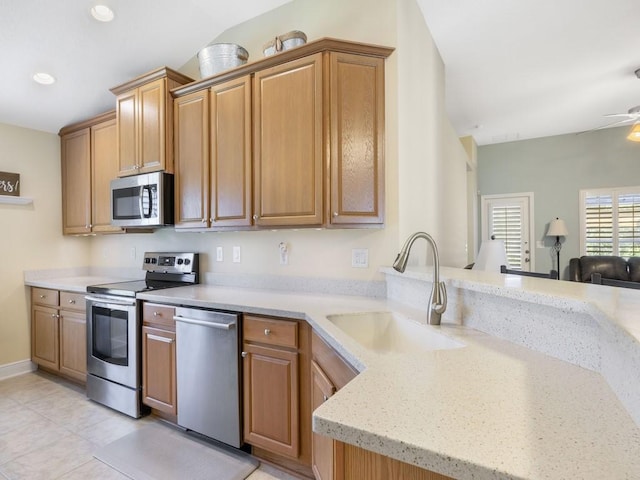 1206 Briarcliff Ct, Sebastian, FL 32958 - kitchen with appliances with stainless steel finishes, a sink, a peninsula, light stone countertops, and light tile patterned floors