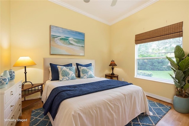 bedroom featuring baseboards, ornamental molding, and wood finished floors