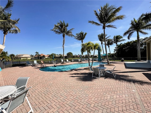 pool with fence and a patio