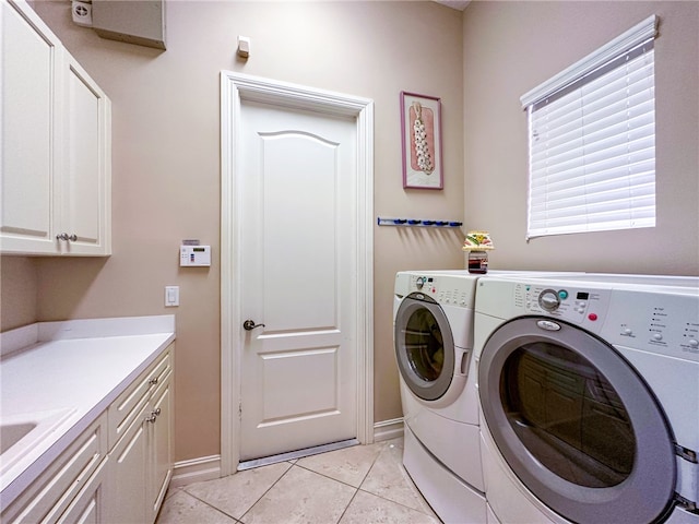 washroom featuring cabinet space, baseboards, separate washer and dryer, a sink, and light tile patterned flooring