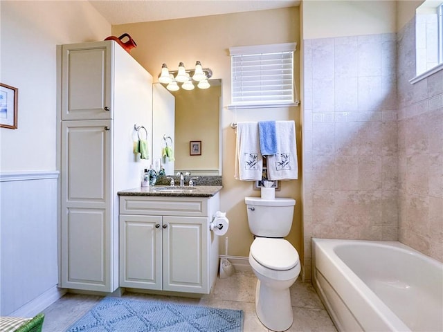 bathroom featuring toilet, vanity, baseboards, tub / shower combination, and tile patterned floors