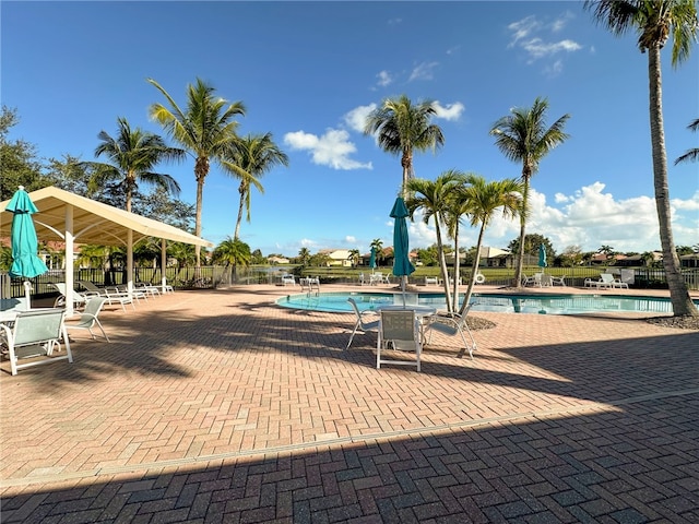 community pool with fence and a patio