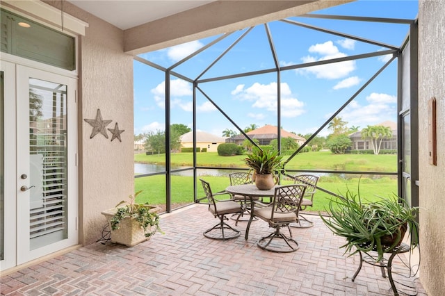 unfurnished sunroom featuring a water view