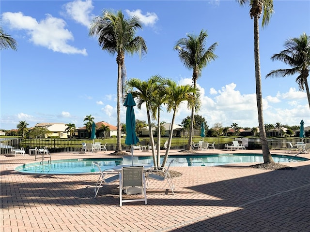 community pool with fence and a patio