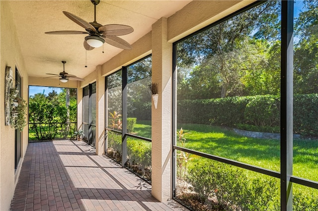 unfurnished sunroom with ceiling fan