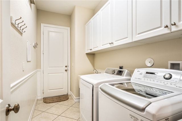 washroom with cabinets, separate washer and dryer, and light tile patterned floors