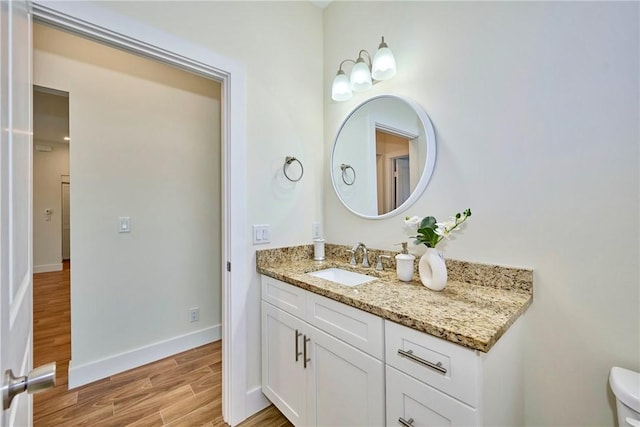 bathroom with wood-type flooring, toilet, and vanity