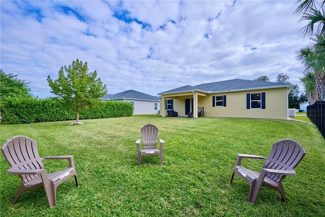 rear view of property featuring a yard