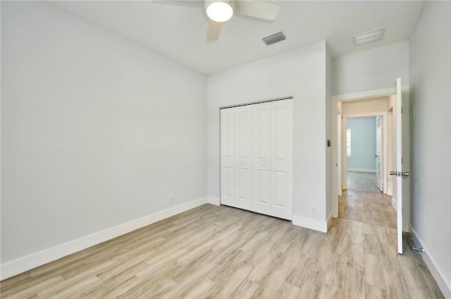 unfurnished bedroom with light hardwood / wood-style floors, a closet, and ceiling fan