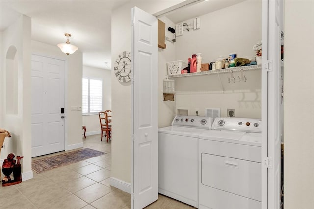 laundry room featuring light tile patterned floors and washing machine and dryer