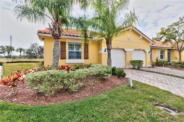 6345 Oxford Cir Unit 101A, Vero Beach, FL 32966 - view of front facade featuring stucco siding, decorative driveway, a tiled roof, and an attached garage