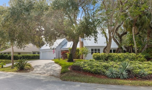 view of front of house with metal roof, driveway, and an attached garage