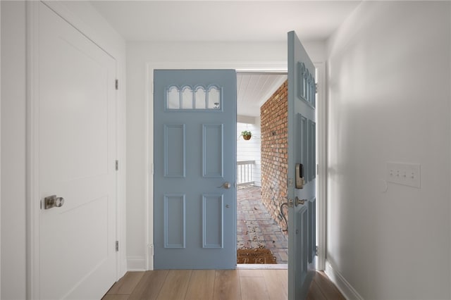 foyer entrance with wood finished floors and baseboards