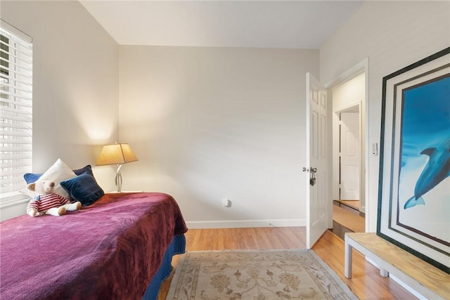 bedroom with multiple windows and light wood-type flooring