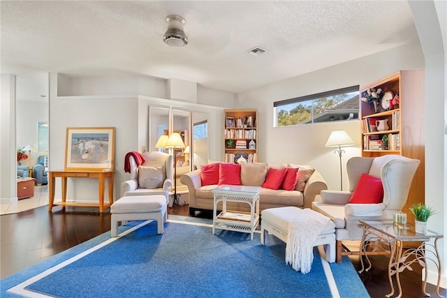 living room with wood-type flooring and a textured ceiling