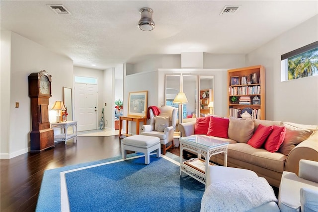 living room with dark wood-type flooring and a textured ceiling