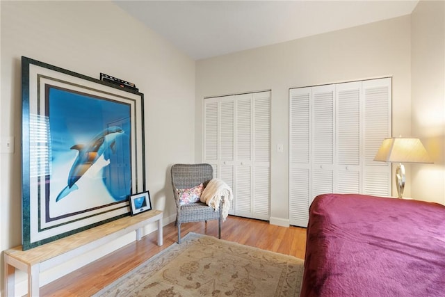 bedroom featuring multiple closets and hardwood / wood-style floors