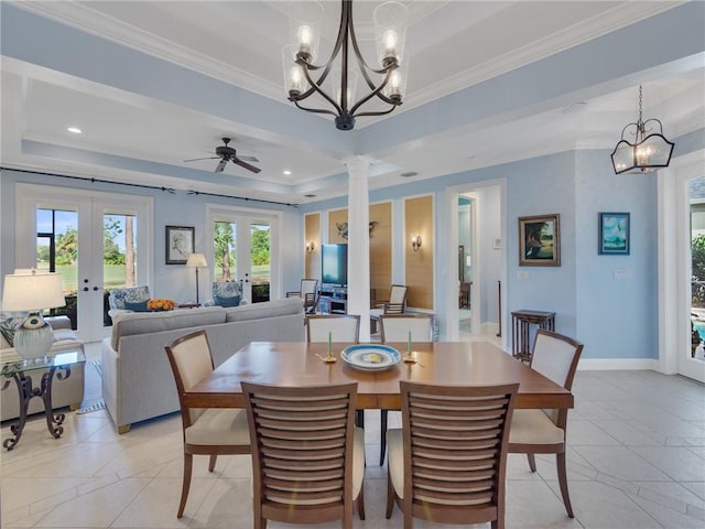 dining area featuring french doors, ceiling fan, ornamental molding, a tray ceiling, and decorative columns