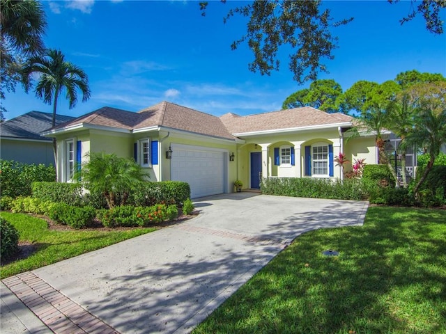 view of front of property featuring a garage and a front lawn