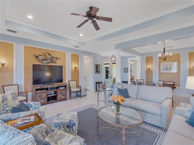 tiled living room with ceiling fan with notable chandelier and a tray ceiling