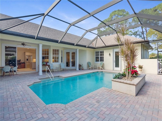 view of pool with ceiling fan, a patio, glass enclosure, and french doors