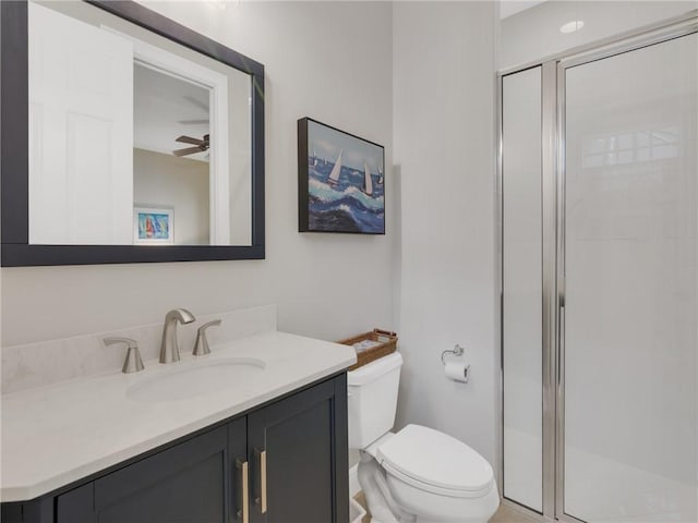 bathroom with vanity, toilet, an enclosed shower, and ceiling fan