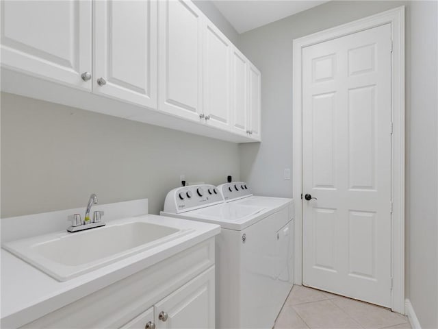 clothes washing area with washer and dryer, cabinets, light tile patterned floors, and sink