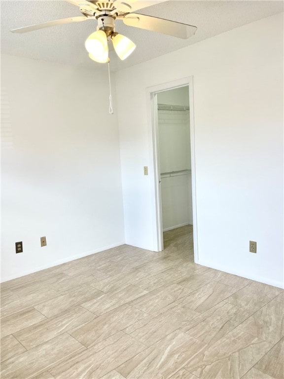 unfurnished room featuring ceiling fan and a textured ceiling