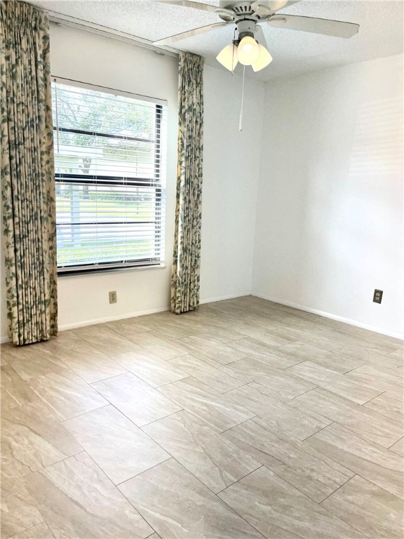 spare room with a textured ceiling and ceiling fan