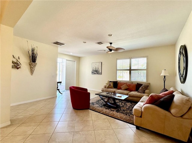 living area with light tile patterned floors, visible vents, and a textured ceiling