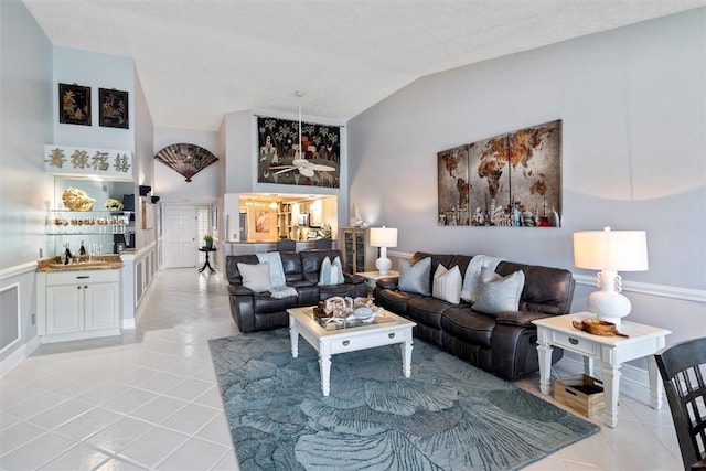 living room with light tile patterned flooring and high vaulted ceiling