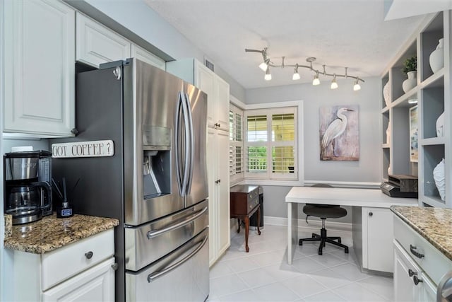 kitchen with white cabinetry, stainless steel fridge with ice dispenser, light stone counters, and light tile patterned flooring