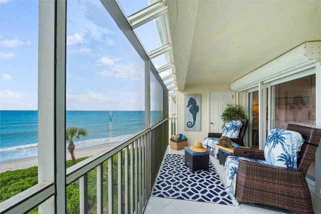 balcony featuring a water view and a beach view