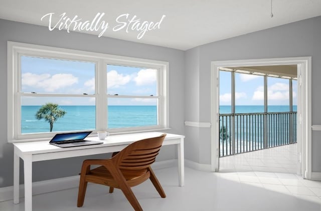 office space featuring baseboards and a water view
