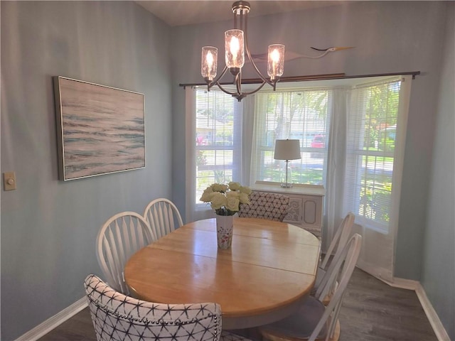 dining space with baseboards, dark wood-style flooring, and an inviting chandelier