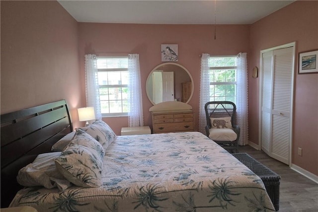 bedroom featuring a closet, wood finished floors, and baseboards