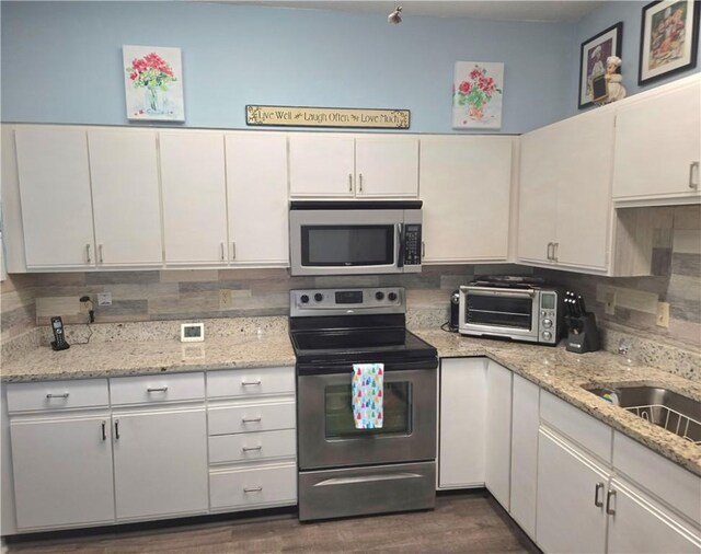 kitchen featuring white cabinetry, stainless steel appliances, tasteful backsplash, and a toaster