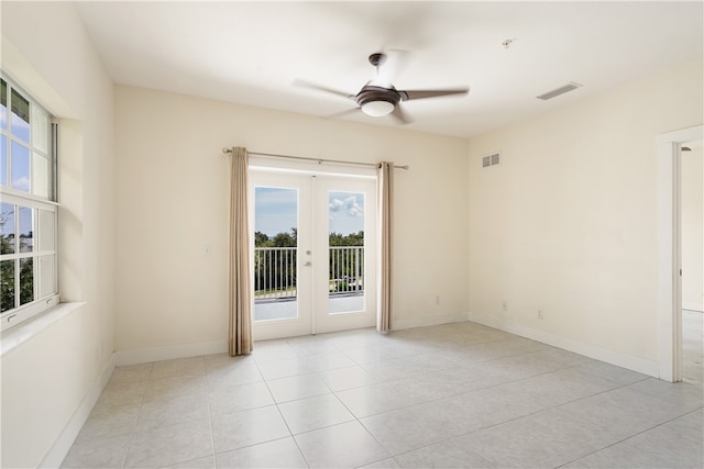 unfurnished room featuring ceiling fan, plenty of natural light, light tile patterned floors, and french doors