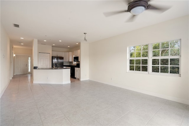 unfurnished living room featuring light tile patterned floors and ceiling fan