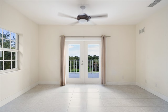 spare room with french doors, a healthy amount of sunlight, ceiling fan, and light tile patterned floors