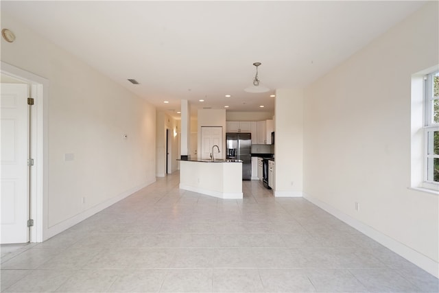 unfurnished living room with light tile patterned floors and sink