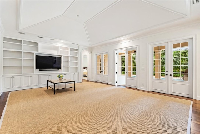 121 Palm Island Ln, Vero Beach, FL 32963 - unfurnished living room featuring french doors, ornamental molding, built in shelves, wood finished floors, and lofted ceiling